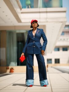 Fitted dark-wash denim-on-denim workwear set with gold buttons and red accessories.