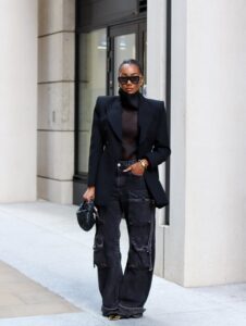 Minimalist street-style corporate outfit featuring a black double-breasted blazer and black straight-leg utility jeans.